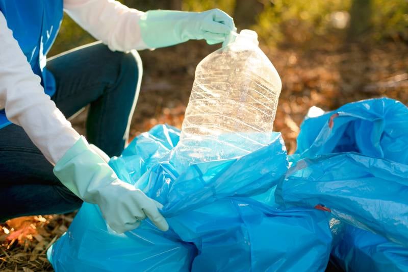 Close-up of hands collecting plastic for recycling
